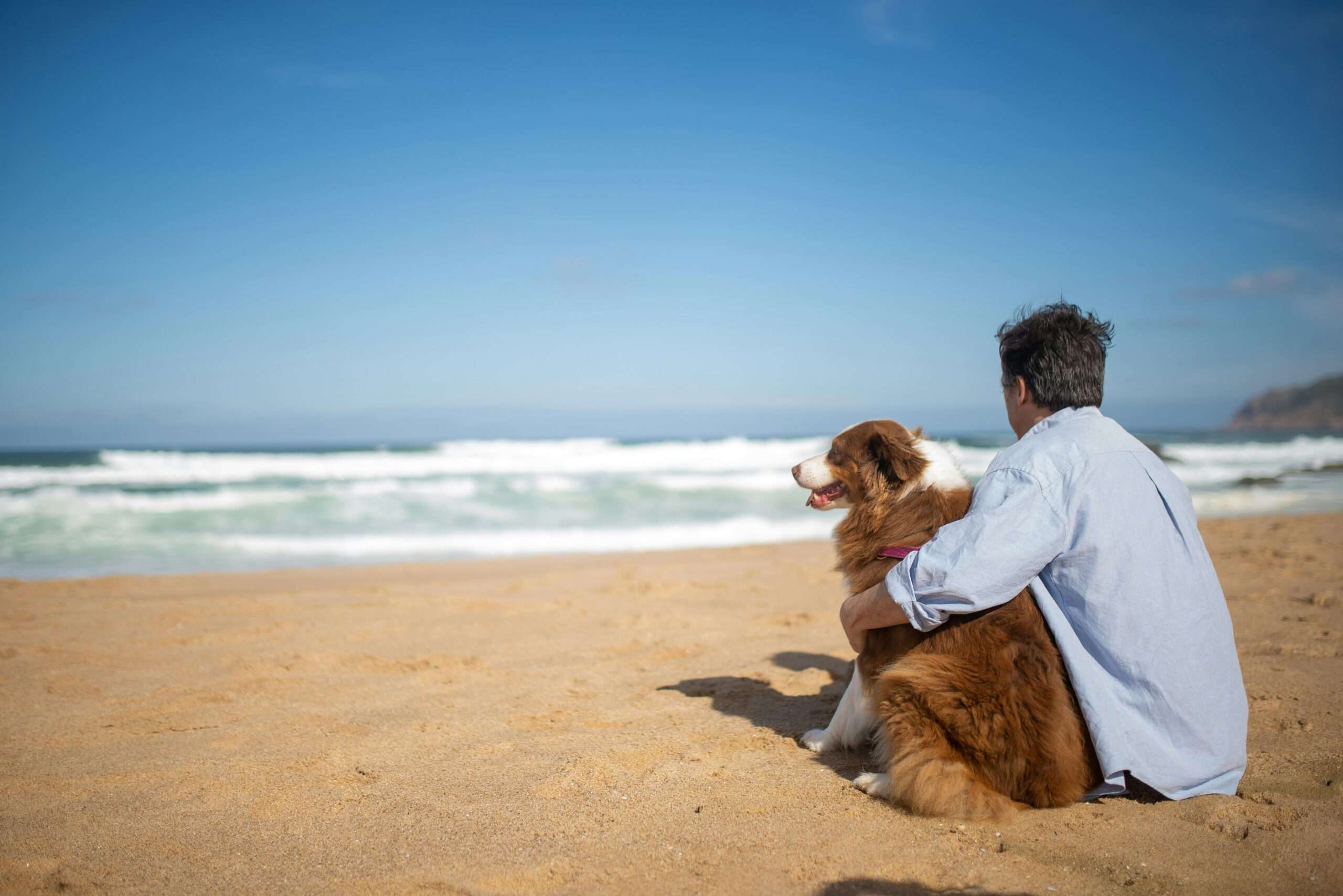 australian man on beach with dog